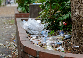 公園の植え込みに散乱したゴミと廃棄物