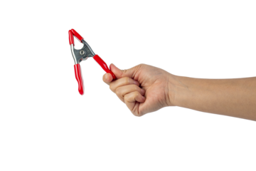 A studio shot of a red stainless spring clamp in hand isolated on a transparent background