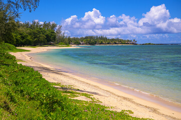 Clear turquoise water and white sandy shoreline at St. Felix Public Beach in southern Mauritius.