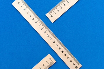 Wooden measuring ruler on blue background