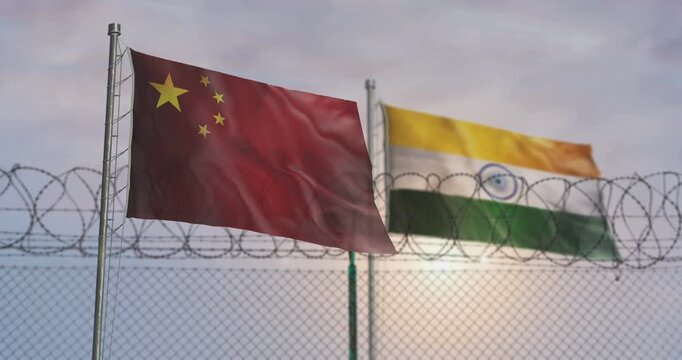 China and India waving flags on country border concept. Chinese and Indian blowing banner with barbed wire fence.