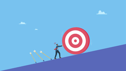 Businessman trying hard to push dartboard or arrow target up the hill. Missed target, failure or obstacle, difficulty in work that hard to achieve target or set too high or unrealistic goal.