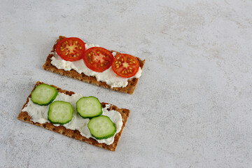 Healthy Crispbread Snacks with Cream Cheese, Tomato and Cucumber slices copy space