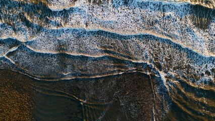 Top-Down Aerial View of Waves Crashing Onto a Sandy Beach