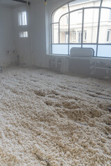 Texture naturelle de laine de bois d'isolation soufflée à la machine, douce et fibreuse, évoquant authenticité, artisanat et matières textiles naturelles pour rénovation énergétique du plancher maison © Thomas