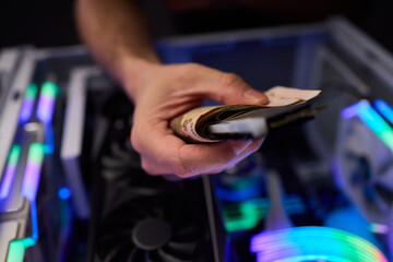 Hidden cash stored in computer memory modules, Covert operation involving cash hideaway inside memory hardware amid colorful RGB illumination and mining equipment