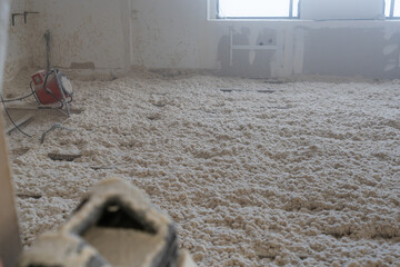 Texture naturelle de laine de bois d'isolation soufflée à la machine, douce et fibreuse, évoquant authenticité, artisanat et matières textiles naturelles pour rénovation énergétique du plancher maison © Thomas