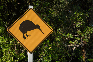 Iconic New Zealand black on yellow warning sign of kiwi bird crossing the road.