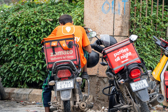 Food delivery rider from Swiggy with a zomato bag showing the multi hatting with food technology apps that the gig workers do to ensure sustainable income