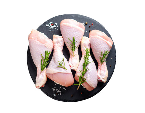 flesh from chickens. On a slate black platter, fresh raw chicken drumsticks are prepared for cooking. on a background of rough stone. Close-up, cut out