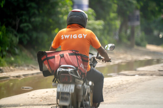 Food delivery rider from Swiggy with a zomato bag showing the multi hatting with food technology apps that the gig workers do to ensure sustainable income