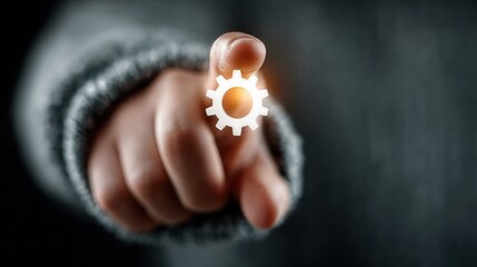 Person pointing at glowing gear symbol, representing settings or process. Hand gesture