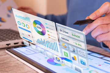 Person using a stylus to navigate a virtual financial dashboard showing data visualization, charts, and online payment options, representing modern taxation and calculation technology