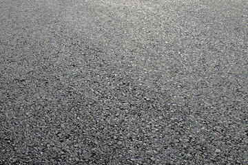 Close-up of a new asphalt road surface texture in bright daylight.