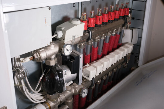 Close-up of radiant floor heating manifold with flow meters and pressure gauge. Concept of modern engineering, efficient thermal energy distribution, and reliable heating system maintenance - Powered by Adobe