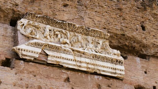 white marble architectural fragment carved acanthus leaves mythological figures embedded brick wall baths caracalla rome up close of italy emperor 