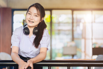 portrait asian teen girl ,highschool student in uniform on school campus happy smiling