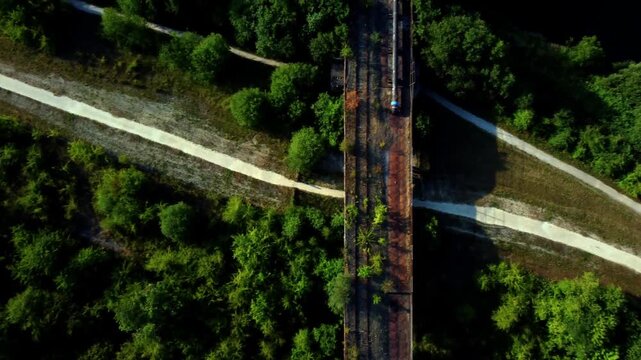 Smooth aerial bird&rsquo;s-eye flyover following full length of abandoned cast iron railway viaduct