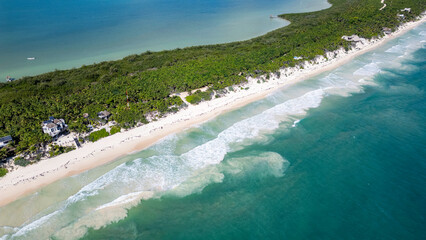 Sian Kaan Biosphere Mexico Beach with a lot of people and a lot of trees. The beach is very crowded. The water is very blue