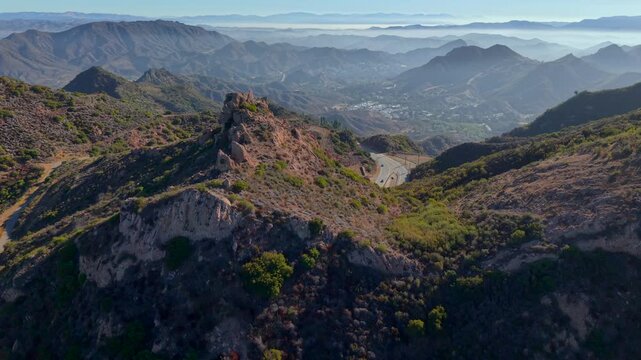 Driving Through Mountain Valley Highway - Malibu Canyon Road in Santa Monica Mountains, California. Sunrise Drone view of a winding mountain roads between the coast and inland valleys.