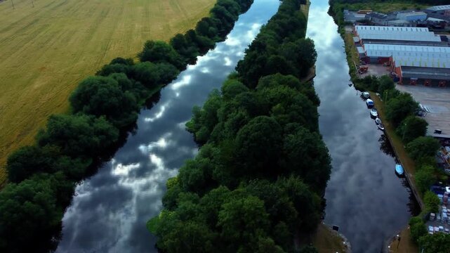 Static aerial gimbal rise over River Aire and Aire and Calder Canal with stunning cloud reflections on the water