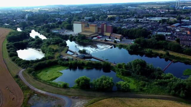 Aerial flight along River Aire revealing large weir at Ferrybridge in Yorkshire