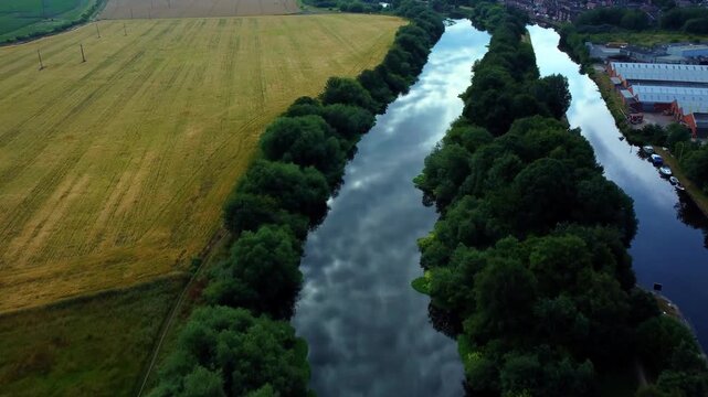 Aerial flight over the River Aire and parallel canal showing amazing cloud reflections on water