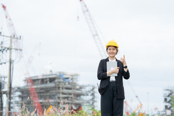 A female engineer is communicating with a company team in an industrial plant, providing support for strategic business decision-making, machine control, and operational efficiency.