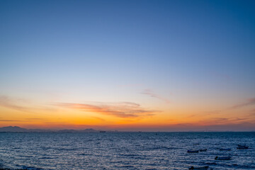 Naklejka premium Sunset Over Calm Ocean Water with Boats