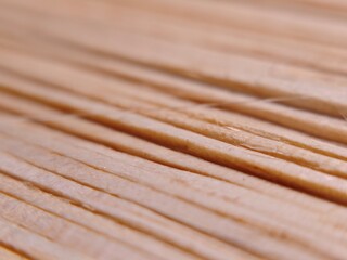A minimalist macro shot of several wooden matchsticks without visible tips, showing the natural grain and texture of the wood scattered on a dark surface