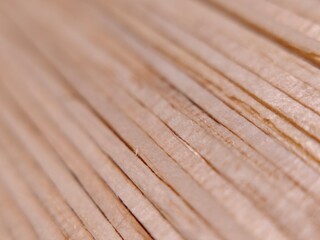 A minimalist macro shot of several wooden matchsticks without visible tips, showing the natural grain and texture of the wood scattered on a dark surface