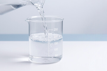 Scientific glass beaker filled with clear liquid against a clean laboratory background, modern research visual ideal for science, chemistry, healthcare, and pharmaceutical concepts.