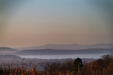 Oklahoma mountaintop view of lake at sunrise with haze and fog