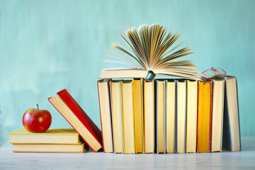 Vintage Books arrangement.Back to school,education,reading, learning, knowledge is power concept with open book,an apple and spectacles.