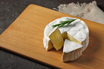 Brie cheese. Camembert cheese. Fresh Brie or Camembert cheese with Rosemary leaves