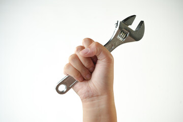 Hand holding an adjustable wrench isolated on white background. Tool concept for repair,...