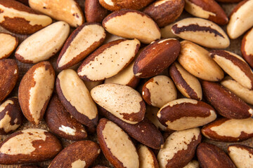 Fototapeta premium Brazil nuts with distinctive creamy interiors and textured brown shells scattered on white.