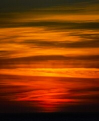 Fototapeta premium Puesta de sol anaranjada en el mar, en un entorno natural.