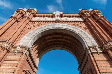 Arc de Triomf brick arch viewed from below against blue sky Barcelona, Spain.