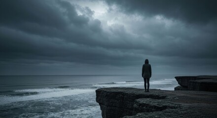 Solitary figure on a cliff overlooking a stormy sea under a dark, brooding sky