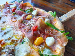 Close up of pizza sliced ​​pork, Cheese, tomatoes. Side view of Italian food on the table