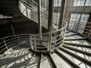 Spiral staircase with metal railings in modern industrial building interior