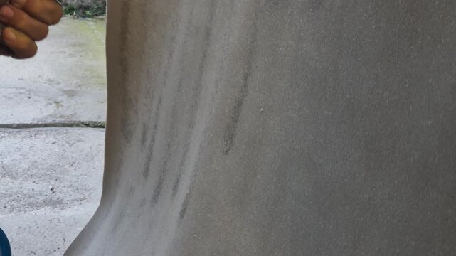 Painting, spraying, concrete wall, worker applying protective coating with a spray gun for industrial maintenance or a DIY project