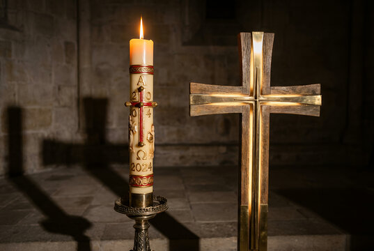Paschal Candle and Illuminated Cross in Dramatic Light