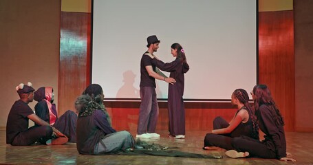 Indian young adult gen z busy male female man woman wear stage outfit dress do couple dance room hall Happy boy girl group sitting look play drama scene clap hands enjoy day time indoor studio place - Powered by Adobe