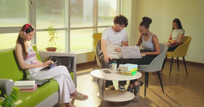Indian young adult gen z girl use laptop hold look screen do e learning check study work pick up cup drink coffee male female talk speak share ideas give high five enjoy new day spend time room place