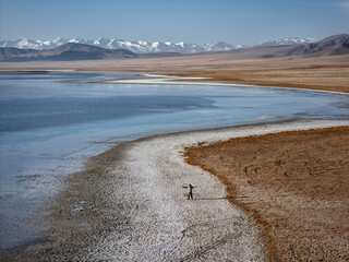 a tourist on the shore of a salt lake