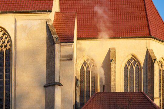 Historic church with red roof and rising smoke in borken - Powered by Adobe