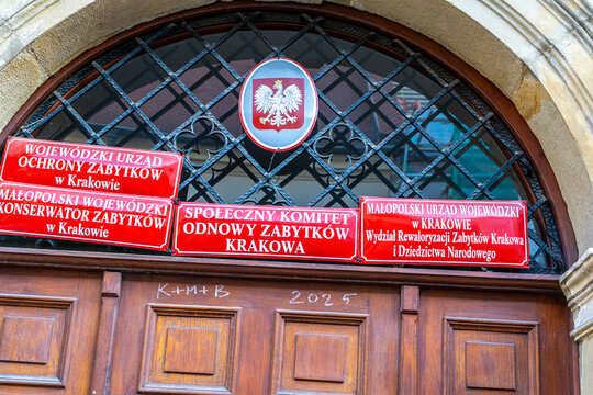 Polish coat of arms Eagle and red plaques of state institutions on the doors. K M B symbol traditional inscription three kings Caspar, Melchior, Balthasar. Krakow, Poland - November 1, 2025