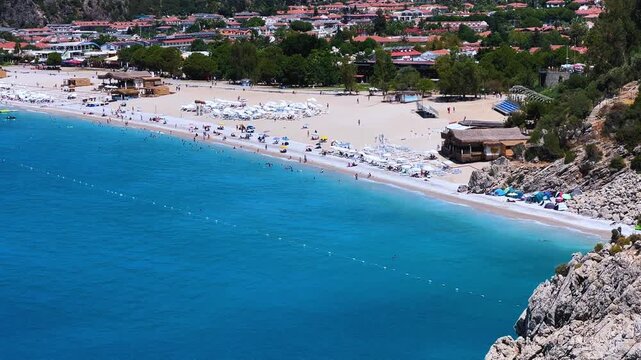 Top view of Oludeniz beach.Oludeniz, or Blue Lagoon, is a beach resort in Turkey.Turquoise waters, sandy coast and green mountains, at the confluence of the Aegean and Mediterranean Seas. 4K